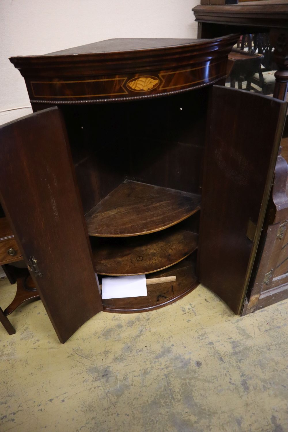 A George III inlaid mahogany bow-fronted hanging corner cupboard,